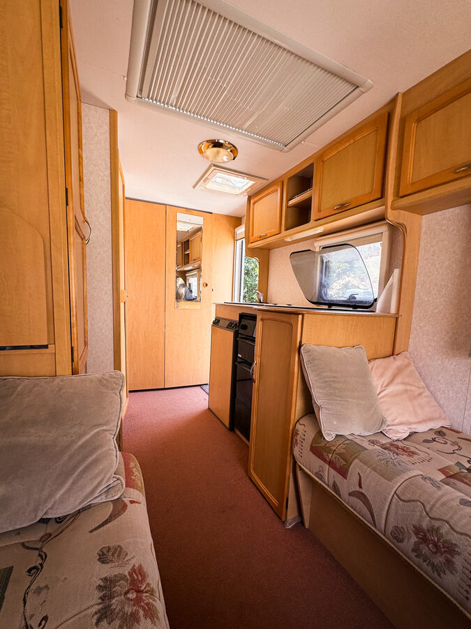 Caravan interior with seating and fridge at Lunar